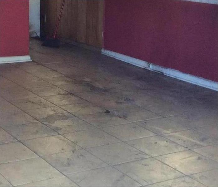 dirty soot and blackened material on walls and tiled floor