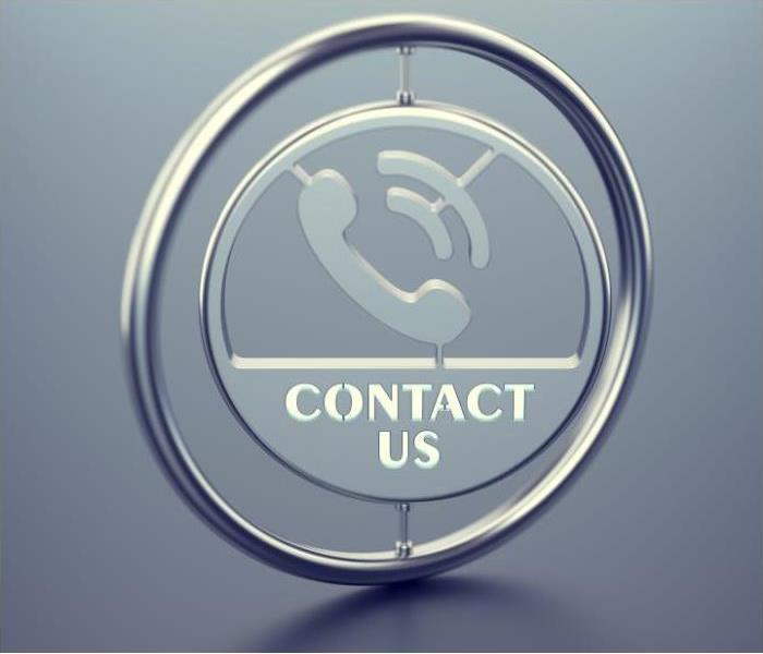 Phone symbol and Contact Us in a silver circle on a grey background